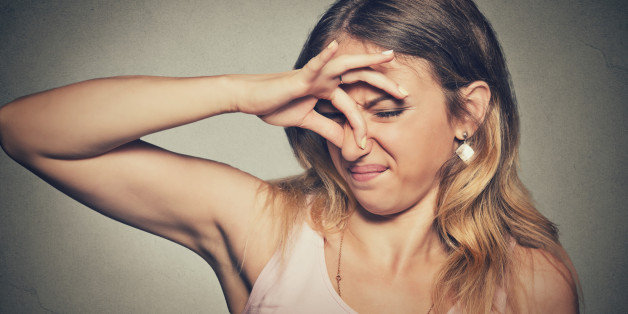 Closeup portrait headshot woman pinches nose with fingers hands looks with disgust something stinks bad smell situation isolated on gray wall background. Human face expression body language reaction