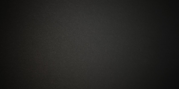 Close-up of a black paper texture background with spotlight.