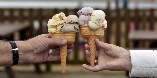 A couple pose with their ice creams on the sea front at Weston Super Mare in south-west England, Britain, in this photograph taken on August 20, 2015. Changing tastes and distribution challenges in emerging markets are opening up an ice cream industry long dominated by global food companies such as Unilever and Nestle. Though classic vanilla, chocolate and strawberry remain the world's most popular ice cream flavors, increasingly health-conscious consumers are moving away from the large tubs of the past to smaller treats. Photograph taken on August 20. REUTERS/Toby Melville