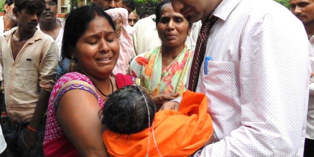 TOPSHOT - EDITORS NOTE: Graphic content / Relatives mourn the death of a child at the Baba Raghav Das Hospital in Gorakhpur, in the northern Indian state of Uttar Pradesh, on August 12, 2017.At least 60 children have died over five days at a government hospital in northern India that suffered oxygen shortages, officials said August 12 amid fears the toll could rise. Authorities said they have launched an inquiry but denied reports that a lack of oxygen had caused the deaths at the Baba Raghav Da