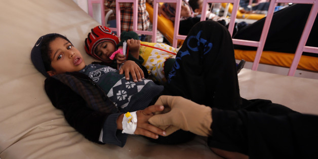 A Yemeni woman holds the hand of one of her children, who is suspected of being infected with cholera, as they receive treatment at a hospital in the capital Sanaa, on August 12, 2017.A cholera outbreak has claimed the lives of some 2,000 Yemenis in less than four months. / AFP PHOTO / Mohammed HUWAIS (Photo credit should read MOHAMMED HUWAIS/AFP/Getty Images)
