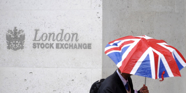 A worker shelters from the rain under a Union Flag umbrella as he passes the London Stock Exchange in London, Britain, October 1, 2008. REUTERS/Toby Melville/File Photo