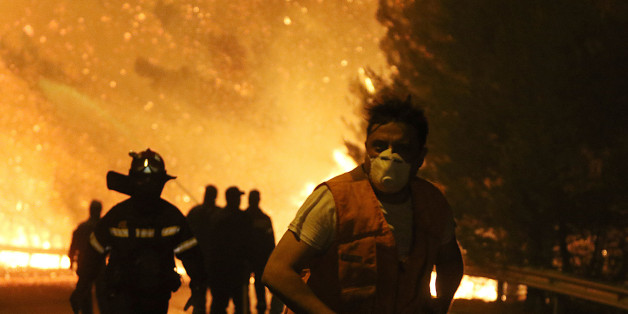 KALAMOS, GREECE - 2017/08/14: A man runs in front of huge blaze during a forest fire in the village of Kalamos. (Photo by Christos Ntountoumis/SOPA Images/LightRocket via Getty Images)