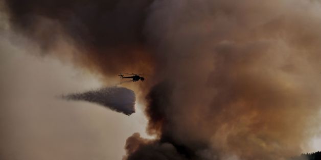 A firefighting helicopter drops waters over a fire, east of the Greek capital Athens on August 15, 2017.
The army was called in to assist firefighters around Kalamos, 45 kilometres (30 miles) east of Athens, where a fire has been burning since August 13. In all, 146 fires have broken out across Greece since then according to authorities.
/ AFP PHOTO / ARIS MESSINIS (Photo credit should read ARIS MESSINIS/AFP/Getty Images)