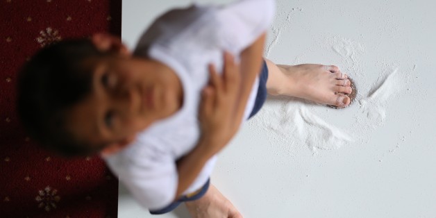 BURSA, TURKEY - JUNE 19 : A junior whirling dervish turns on a salty wedge to prevent any nappy rash during their training session at Culture Centre Of Karabas-i Veli, in Bursa, Turkey on June 19, 2017. The 6-month long training of dervishes includes physical aspects as well as spiritual ones. The trainees perform pray before doing push-ups to make their bodies stronger and to calm their soul pray. Then their trainer let the trainees to kiss a wedge as they kneel down, later on they take salt and put it on a wedge. After that, a trainee stands next to a wooden board with barefoot, bowes on the knees and prostrates to kiss a wedge meaning 'thanks'. Then a trainee sprinkles a small amount of salt to prevent any nappy rash or wound, to a wedge. Following these steps, a trainee places his barefoot on a wedge and starts to turn. Whirling dervishes put their right hands in the palm-up position to receive the blessings of heaven. (Photo by Ali Atmaca/Anadolu Agency/Getty Images)