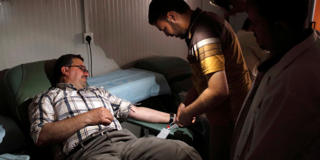 An Iraqi hospital staff member prepares a man for blood donation at Ibn al-Atheer hospital in eastern Mosul, Iraq, May 13, 2017. REUTERS/Danish Siddiqui