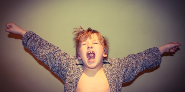 Young boy having a large stretch and yawn