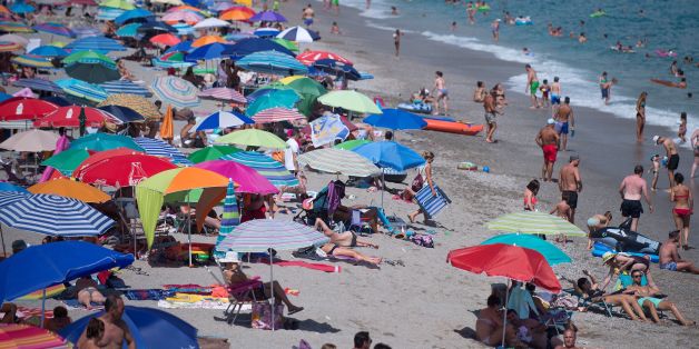 People sunbathe on the Burriana beach in Nerja, near Malaga, on August 12, 2017. / AFP PHOTO / JORGE GUERRERO (Photo credit should read JORGE GUERRERO/AFP/Getty Images)