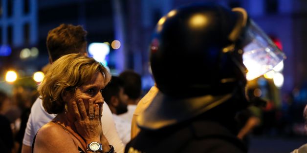 A woman gestures as she is escorted out by Spanish policemen outside a cordoned off area after a van ploughed into the crowd, killing 13 persons and injuring over 80 on the Rambla in Barcelona on August 17, 2017.
A driver deliberately rammed a van into a crowd on Barcelona's most popular street on August 17, 2017 killing at least 13 people before fleeing to a nearby bar, police said.
Officers in Spain's second-largest city said the ramming on Las Ramblas was a 'terrorist attack'. / AFP PHOTO / PAU BARRENA (Photo credit should read PAU BARRENA/AFP/Getty Images)