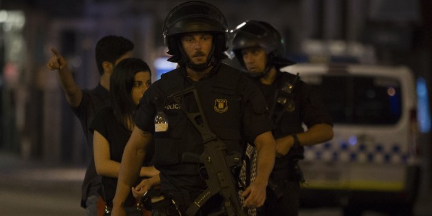 BARCELONA, SPAIN - AUGUST 17: Police officers evacuate people from a shop at Las Ramblas as they take security measures at the area after a van plowed into the crowd, injuring several people in Barcelona, Spain on August 17, 2017. (Photo by Albert Llop/Anadolu Agency/Getty Images)