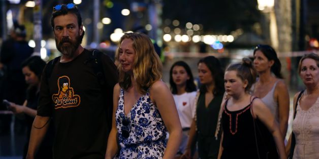 A woman cries as she and others are escorted by Spanish policemen outside a cordoned off area after a van ploughed into the crowd, killing 13 persons and injuring over 80 on the Rambla in Barcelona on August 17, 2017.A driver deliberately rammed a van into a crowd on Barcelona's most popular street on August 17, 2017 killing at least 13 people before fleeing to a nearby bar, police said. Officers in Spain's second-largest city said the ramming on Las Ramblas was a 'terrorist attack'. / AFP PHOTO