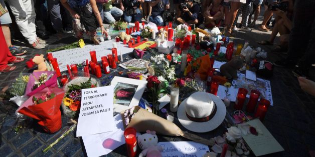 People stand next to flowers, candles, a sign reading ' Out terrorism and attacks, we want peace' and other items set up on the Las Ramblas boulevard in Barcelona as they pay tribute to the victims of the Barcelona attack, a day after a van ploughed into the crowd, killing 13 persons and injuring over 100 on August 18, 2017.
Police hunted for the driver who rammed a van into pedestrians on an avenue crowded with tourists in Barcelona, leaving 13 people dead and more than 100 injured, just hours before a second assault in a resort along the coast. / AFP PHOTO / PASCAL GUYOT (Photo credit should read PASCAL GUYOT/AFP/Getty Images)