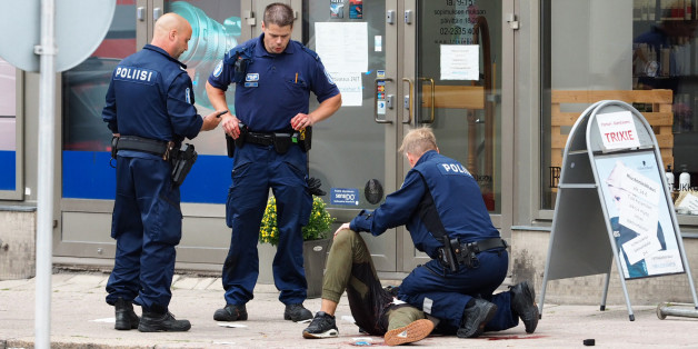 TOPSHOT - Police officers detain a suspect, in the Finnish city of Turku where several people were stabbed, on August 18, 2017. Several people were stabbed in the southwestern Finnish city of Turku, police said after shooting and arresting a suspect. Public television station Yle reported that central Turku was on lockdown, with witnesses saying they had seen bodies lying on the ground in a busy area of the town. Businesses were shut. / AFP PHOTO / Kirsi Kanerva (Photo credit should read