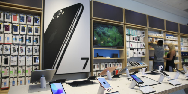 Apple Inc. iPhones and iPad tablet computers are displayed for sale at an AT&T Inc. store in Newport Beach, California, U.S., on Thursday, Aug. 10, 2017. AT&T Inc. shares surged the most in more than eight years after the telecommunications giant posted a surprise wireless subscriber gain in the second quarter, showing it can fend for itself in a cutthroat price war. An offer for unlimited wireless data, bundled with discounted streaming-TV service, helping AT&T bide its time while awaiting regu