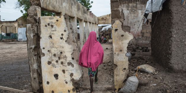 TOPSHOT - A girl walks through the site where the Nigerian Air Force (NAF) mistakenly bombed the Rann Internally-Displaced Peoples (IDP) camp in northeastern Nigeria near the Cameroonian border on July 29, 2017.On January 17, 2017 the Rann Internally-Displaced Persons (IDP) camp was bombed by the Nigerian Air Force (NAF), injuring hundreds of people, killing dozens of civilians and at least six humanitarian workers, in the mistaken belief that the large congregation of people was a Boko Haram mi