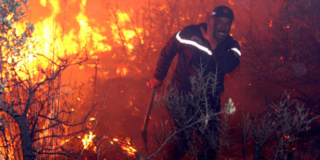 An fireman struggles against a fire, late 01 September 2007 night in Tzarift, near Tlemcen, north-west of Algeria. Cooler temperatures in northern Algeria helped firefighters put out most of the blazes that have killed at least eight people and ravaged huge swathes of forest over the past 48 hours. AFP PHOTO STR (Photo credit should read STR/AFP/Getty Images)