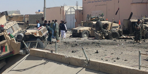 Afghan security personnel inspect the site of a suicide attack near the main police headquarters in Lashkar Gah, capital of Helmand province, on August 23, 2017.
A Taliban suicide bomber killed five people and wounded dozens of others, mainly children as young as five, when he detonated a car packed with explosives at a police headquarters in southern Afghanistan on August 23. / AFP PHOTO / STR (Photo credit should read STR/AFP/Getty Images)