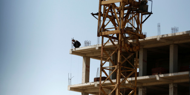 A worker looks down from the top of a new apartment building being built at a construction site in Algiers, Algeria May 3, 2016. REUTERS/Zohra Bensemra