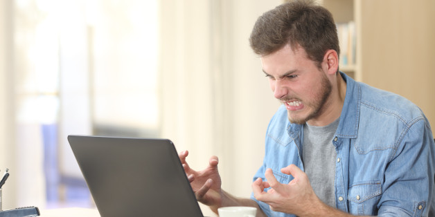 Entrepreneur angry and furious with a laptop in a little office or home