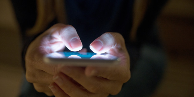 Female using her mobile phone outside at night