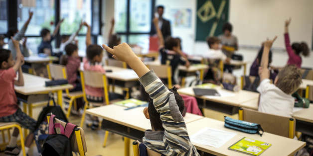 Pupils raise their hands in a classroom at the Germaine Tillion primary school, on September 4, 2012 at the start of the new school year in Lyon, eastern France. Tillion (1907-2008) was a French anthropologist, specialist of Algeria and resistant fighter during World War II. AFP PHOTO / (Photo credit should read JEFF PACHOUD/AFP/GettyImages)