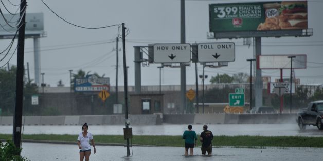 TOPSHOT - People walk dogs through flooded streets as the effects of Hurricane Harvey are seen August 27, 2017 in Galveston, Texas.
Hurricane Harvey left a trail of devastation Saturday after the most powerful storm to hit the US mainland in over a decade slammed into Texas, destroying homes, severing power supplies and forcing tens of thousands of residents to flee. / AFP PHOTO / Brendan Smialowski (Photo credit should read BRENDAN SMIALOWSKI/AFP/Getty Images)