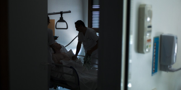 Nurses treat a patient at the palliative care unit of the Argenteuil hospital in the suburbs of Paris on July 22, 2013. AFP PHOTO / FRED DUFOUR (Photo credit should read FRED DUFOUR/AFP/Getty Images)