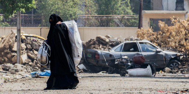 A woman is fleeing from a neighbourhood in western Mosul where fights between the federal Police and ISIS are taking part (Photo by Sebastian Backhaus/NurPhoto via Getty Images)