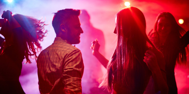 Happy couple and their friends dancing in disco club