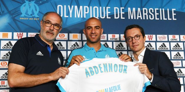 Olympique de Marseille's newly recruited player, Tunisien defender Aymen Abdennour (C), holds his new jersey next to Olympique de Marseille French president Jacques-Henri Eyraud (R) and Olympique de Marseille's sportive manager Andoni Zubizarreta during his official presentation, on August 30, 2017 at the Robert-Louis Dreyfus training centre in Marseille, southern France. Tunisian international defender Aymen Abdennour has joined Marseille on loan from Valencia, the French club announced on Augu