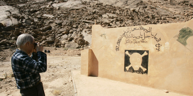 Hiroshima survivor Sunao Tsuboi takes a photograph at a French nuclear tests' site in In-Ekker near Ain Maguel, 170 km (106 miles) from the southern Algerian town of Tamanrasset, February 16, 2007. France should apologise for atom bomb tests in its former colony Algeria which were an atrocious crime that harmed humans and the environment, an Algerian official said on Tuesday. The Arabic script reads: "Nuclear tests site of the former French colony from 1960 to 1967 in Taorirt mountain in In-Ekke