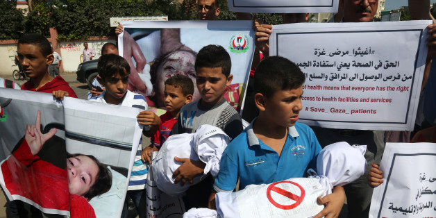 Palestinian children hold placards upon arrival of United Nations Secretary General Antonio Guterres in Beit Lahia in the northern Gaza Strip on August 30, 2017. (Photo by Majdi Fathi/NurPhoto via Getty Images)