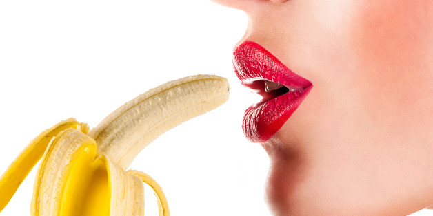 sexy woman eating banana isolated on white background