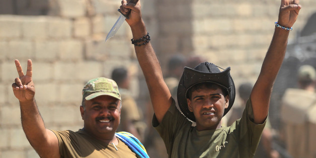 Iraqi forces flash the sign for victory as they advance towards the al-Ayadieh area, north of Tal Afar, during the ongoing battle to oust the last pockets of Islamic State group jihadists from the area on August 30, 2017. Jihadists inside Tal Afar were believed to have fled to Al-Ayadieh, located on the road between the city and the Syrian border, where they appeared to be making a desperate last stand. / AFP PHOTO / AHMAD AL-RUBAYE (Photo credit should read AHMAD AL-RUBAYE/AFP/Getty Imag