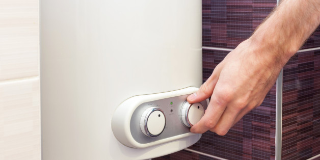 Close-up of man hands setting the temperature of water in Electric Boiler