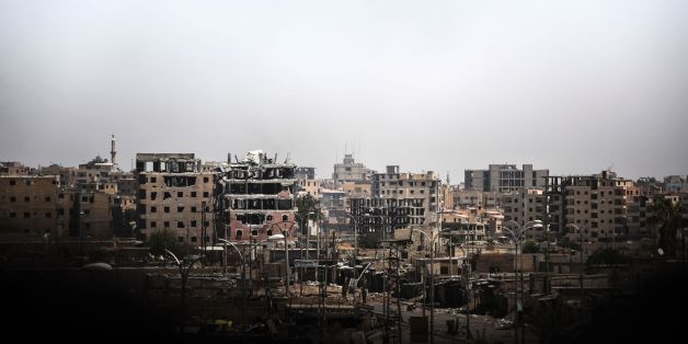 TOPSHOT - Damaged buildings are seen in western Raqa on July 12, 2017, during an offensive by Syrian Democratic Forces (SDF), an alliance of Kurdish and Arab fighters, to retake the city from Islamic State (IS) group fighters.The US-backed coalition has captured around 30 percent of Raqa city since it entered the IS bastion in June after a months-long operation to capture territory in the surrounding province. / AFP PHOTO / BULENT KILIC (Photo credit should read BULENT KILIC/AFP/Getty Ima