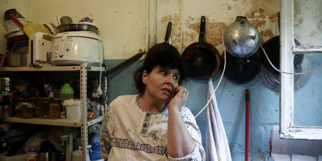 Emine Kilic, a Turkish squatter and mother of 10, speaks on the phone inside a kitchen at the "Prosfygika" housing complex in Athens November 24, 2013. It has been shelled, threatened with demolition and became such an eyesore that it was covered by a massive sheet during the 2004 Athens Olympics, but the historic 1930s housing complex built for Greeks fleeing Turkey is a hive of activity again. As Greece's six-year economic slump has increased the number of homeless to 20,000 in Athens alone, NGOs estimate, the "Prosfygika" complex has become a haven for squatters and drug addicts as well as immigrants from Iran and elsewhere trying to cross into northern Europe through Greece's porous borders. Picture taken November 24, 2013. REUTERS/Yorgos Karahalis (GREECE - Tags: SOCIETY IMMIGRATION POVERTY)