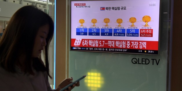 A woman walks past a television display at a train station in Seoul on September 3, 2017 showing a news broadcast with a graphic about a history of North Korean nuclear tests after news Pyongyang might have conducted a sixth test.North Korea appeared to carry out a sixth nuclear test on September 3, with seismic monitors measuring an 'explosion' of 6.3 magnitude near its main test site, sending tensions over its weapons ambitions to new heights. / AFP PHOTO / Ed JONES (Photo credit should
