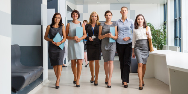 Group of confident businesswomen walking down the hall in modern interior.
