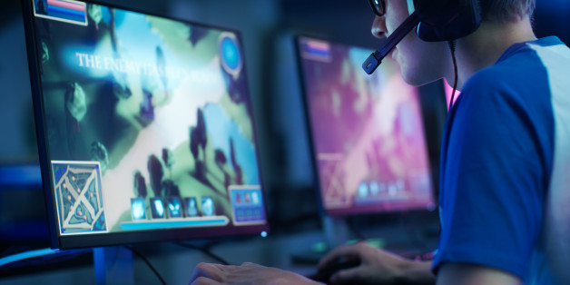 Team of Professional eSport Gamers Playing in Competitive MMORPG/ Strategy Video Game on a Cyber Games Tournament. They Talk to Each other into Microphones. Arena Looks Cool with Neon Lights.