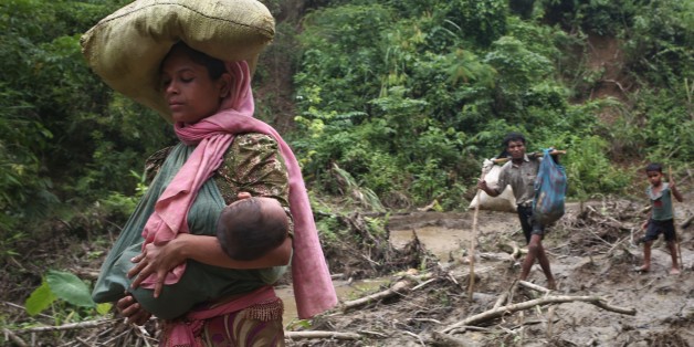 A rohingya woman carries her child in a sling while walks through in hill after crossing the border into Bangladesh near cox's bazar area, teknaf. September 5, 2017 A total of 87,000 mostly Rohingya refugees have arrived in Bangladesh since violence erupted in neighbouring Myanmar on August 25, the United Nations said today, amid growing international criticism of Aung San Suu Kyi. Around 20,000 more were massed on the border waiting to enter, the UN said in a report. (Photo by Mushfiqul Alam/
