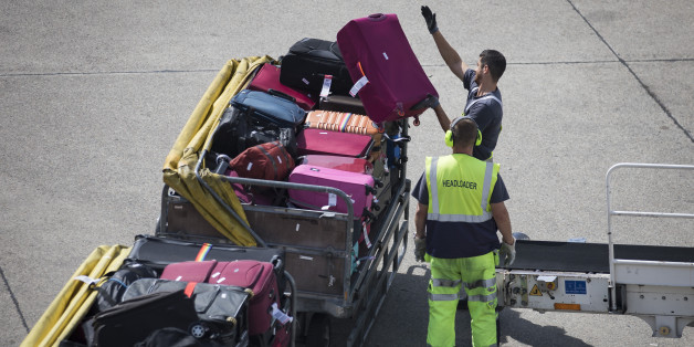 Airport staff unloads luggage from a plane at Tegel Airport on August 8, 2017 in Berlin. / AFP PHOTO / AXEL SCHMIDT (Photo credit should read AXEL SCHMIDT/AFP/Getty Images)