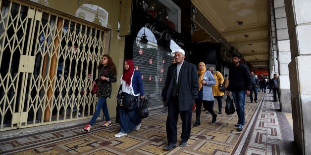 Tunisians walk past shops closed by their owners as part of a one-day strike in protest against the increase of the numbers of street vendors in the centre of Tunis on March 28, 2017. / AFP PHOTO / FETHI BELAID (Photo credit should read FETHI BELAID/AFP/Getty Images)