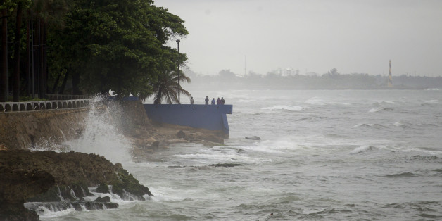 People stand by the sea in the rain in the La Cienaga neighborhood on September 7, 2017, as Hurricane Irma approaches.
Irma was packing maximum sustained winds of up to 185 mph (295 kph) as it followed a projected path that would see it hit the northern edges of the Dominican Republic and Haiti on Thursday, continuing past eastern Cuba before veering north for Florida. / AFP PHOTO / Erika SANTELICES (Photo credit should read ERIKA SANTELICES/AFP/Getty Images)