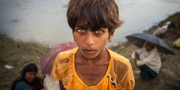 A Rohingya ethnic minority girl from Myanmar poses as they alight from a local boat on which they crossed a river, after crossing over to the Bangladesh side of the border near Cox's Bazar's Whykkyong Lamba Bill area, Thursday, Sept. 7, 2017. Tens of thousands more people have crossed by boat and on foot into Bangladesh in the last two weeks as they flee violence in western Myanmar. (Photo by Ahmed Salahuddin/NurPhoto via Getty Images)