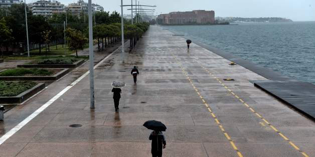 People walk with umbrellas under a rainfall on the waterfront of Thessaloniki on July 17, 2017.
Greeks are bearing the brunt of a weather phenomenon called Medusa with heavy rains, hailstorms, and strong winds. / AFP PHOTO / SAKIS MITROLIDIS (Photo credit should read SAKIS MITROLIDIS/AFP/Getty Images)