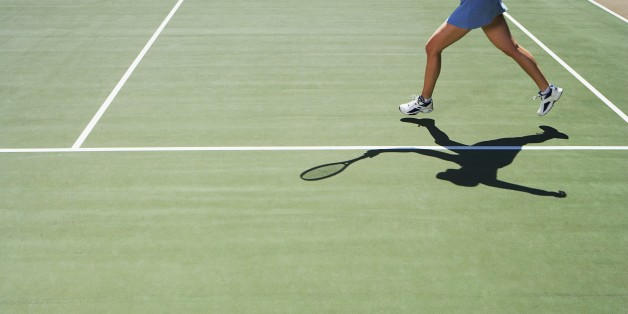 Shadow and legs of person playing tennis