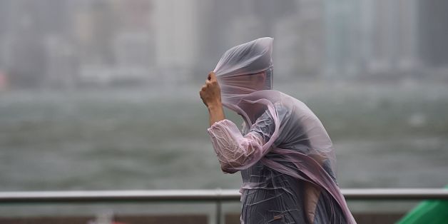 A man shields himself with his plastic poncho during heavy winds and rain brought on by Typhoon Hato in Hong Kong on August 23, 2017.
Typhoon Hato smashed into Hong Kong on August 23 with hurricane force winds and heavy rains in the worst storm the city has seen for five years, shutting down the stock market and forcing the cancellation of hundreds of flights. / AFP PHOTO / Anthony WALLACE (Photo credit should read ANTHONY WALLACE/AFP/Getty Images)