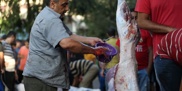 A Palestinian man cleans the carcass of a lamb on September 12, 2016, in Gaza City as Muslims mark the first day of the Muslim feast of Eid al-Adha.Muslims across the world celebrate the annual festival of Eid al-Adha, or the festival of sacrifice, which marks the end of the Hajj pilgrimage to Mecca and commemorates prophet Abraham's readiness to sacrifice his son to show obedience to God. / AFP / MOHAMMED ABED (Photo credit should read MOHAMMED ABED/AFP/Getty Images)