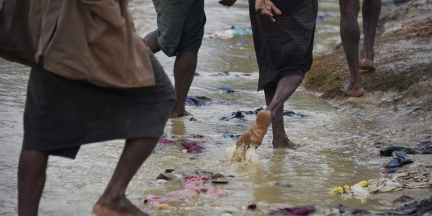 TOPSHOT - Rohingya refugees walks under rain at Kutupalong refugee camp in the Bangladeshi locality of Ukhia on September 19, 2017. Pressure grew on Myanmar on September 18 as a rights group urged world leaders to impose sanctions on its military, which is accused of driving out more than 410,000 Rohingya Muslims in an orchestrated 'ethnic cleansing' campaign. / AFP PHOTO / DOMINIQUE FAGET (Photo credit should read DOMINIQUE FAGET/AFP/Getty Images)
